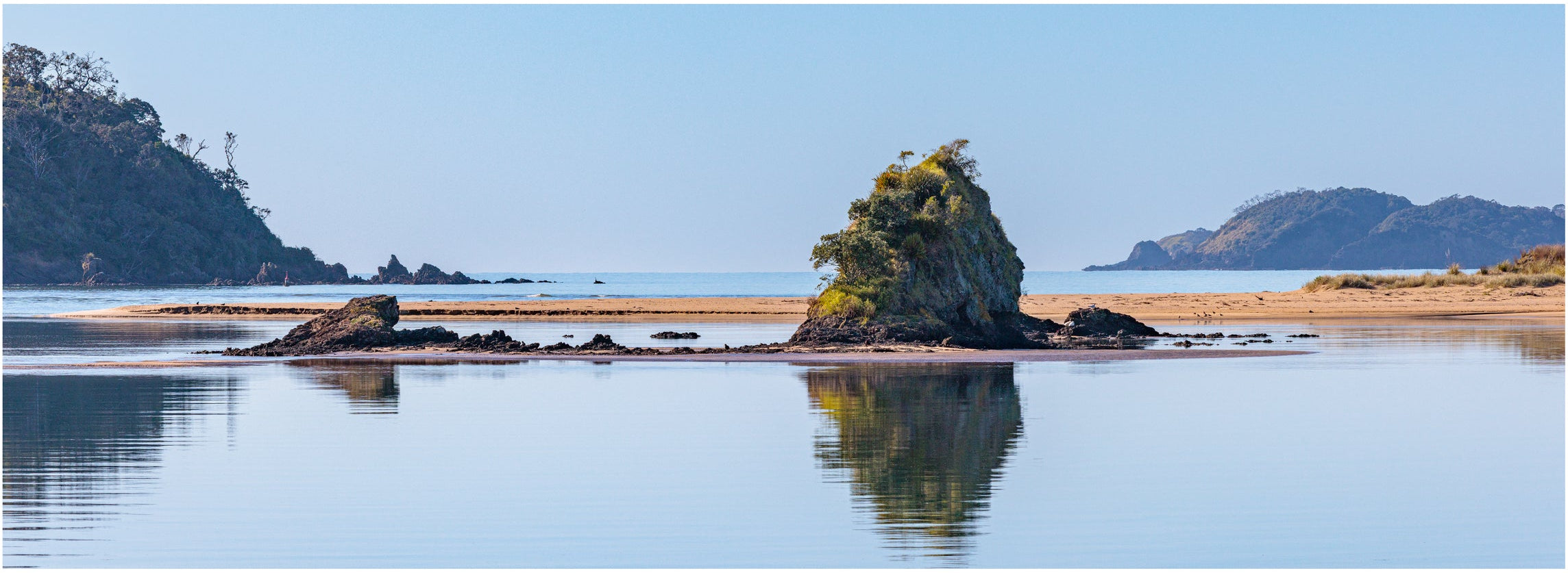 Beach scene with a small island and clear water